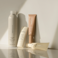 3 pieces of Hydropeptide Solar Defense products laying on a sandy beach